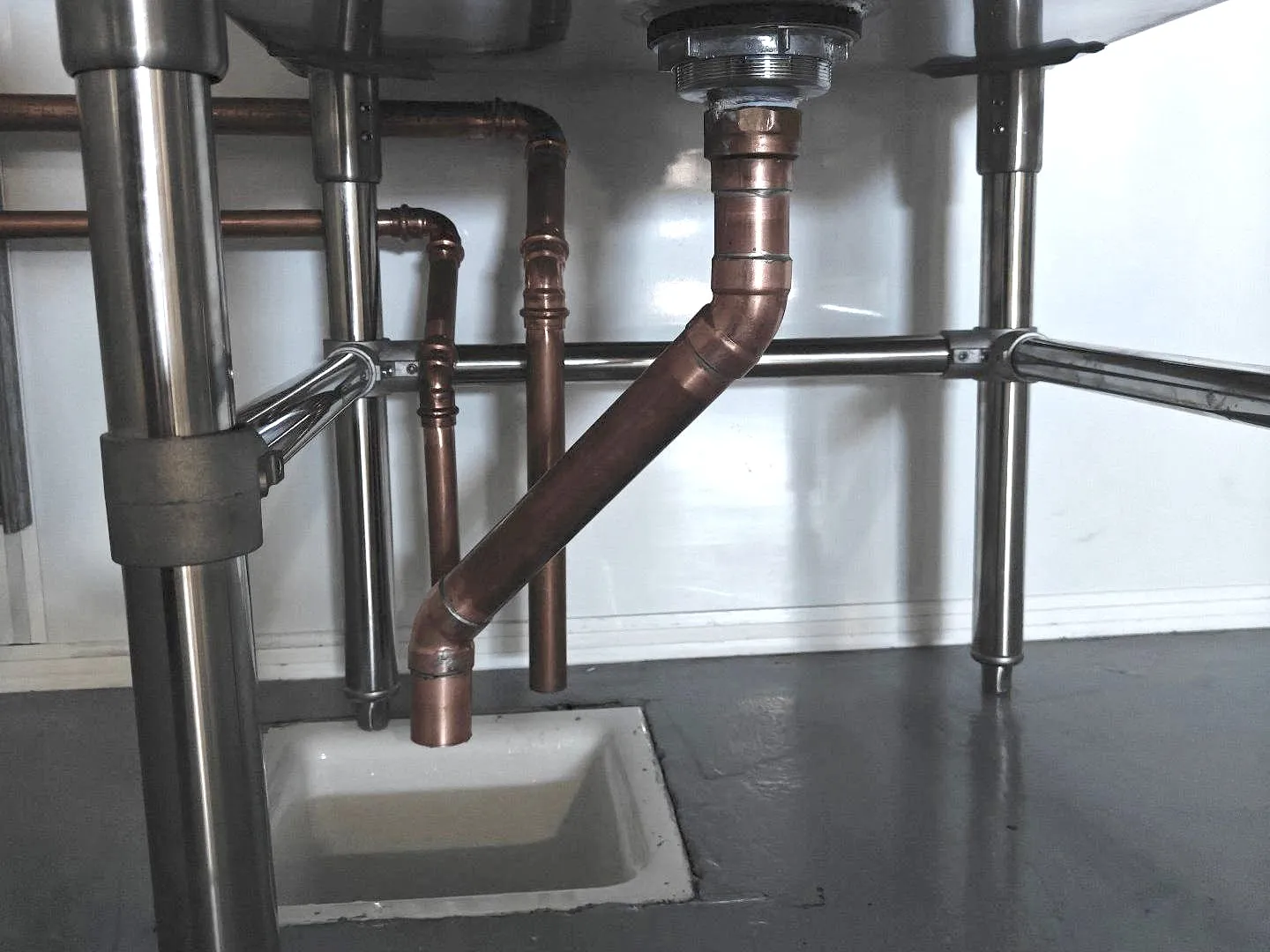 Copper drain from a stainless sink down to a floor sink, ending above it for an air gap