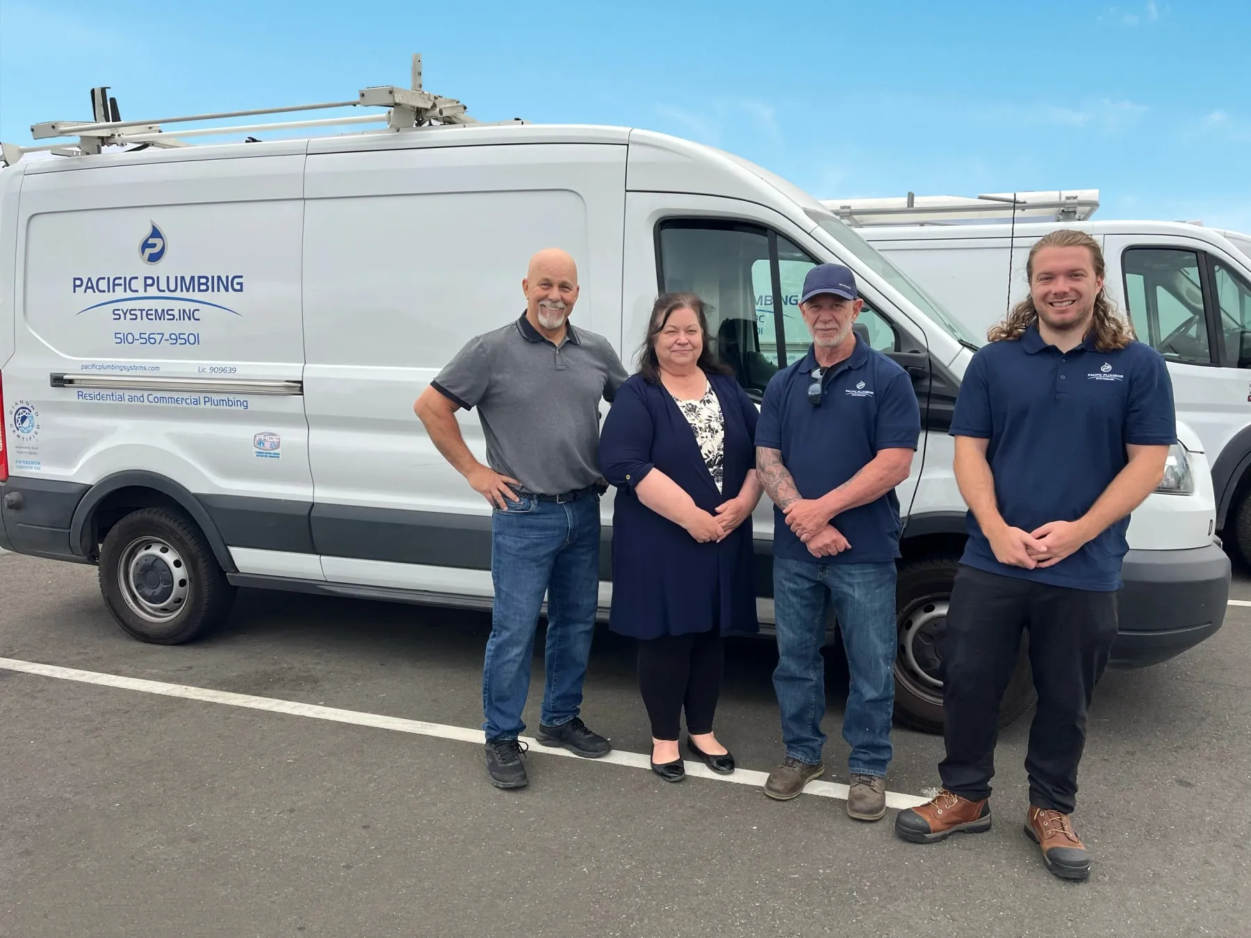 The office team with Ron Beesley in front of the vans